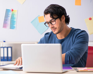 Young handsome designer working at the project