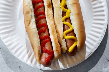 A top down view of a hot dog with ketchup and a hot dog with mustard.