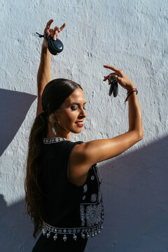 Smiling woman dancing flamenco with castanets