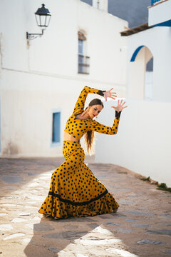 Carefree Hispanic woman bending aside during dance