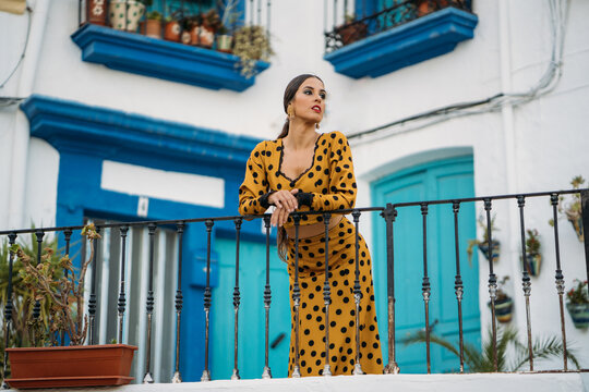 Graceful woman standing on terrace and looking away