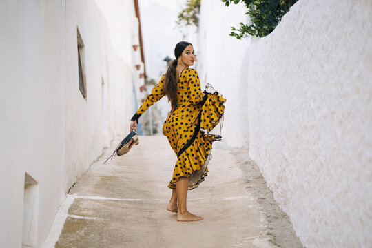 Gorgeous barefooted flamenco woman walking in town