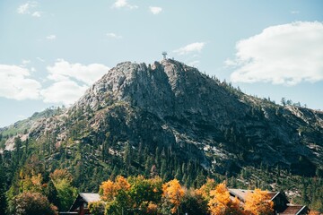 the cabin sits alone beside a mountain side in the fall