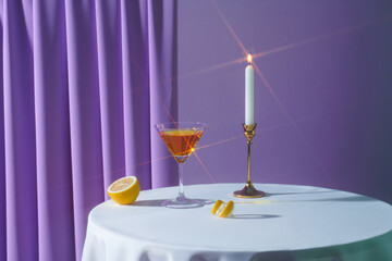 Refreshing martini with lemon twist garnish with tea light candles