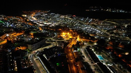 Obraz premium city lights are illuminating from a tall building overlooking a wide beach