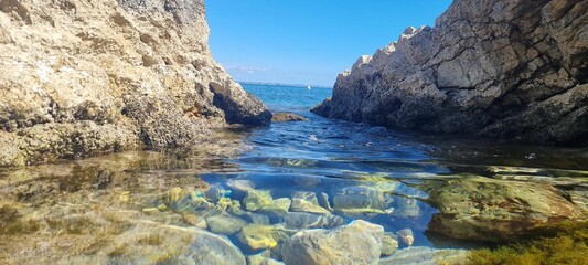 the water in front of some rocky cliffs is clear and blue