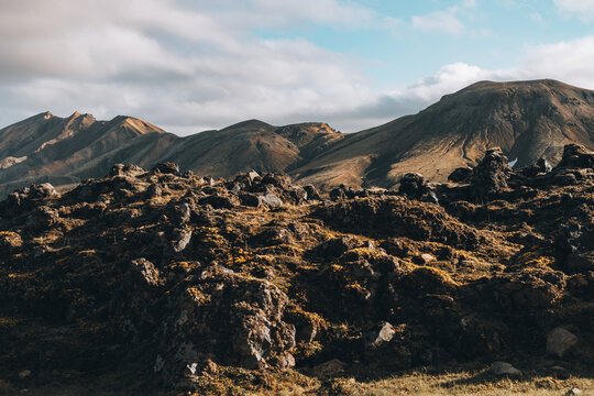 Volcanic Mountains in Mossy Lava Field with Blue Cloudy Sky
