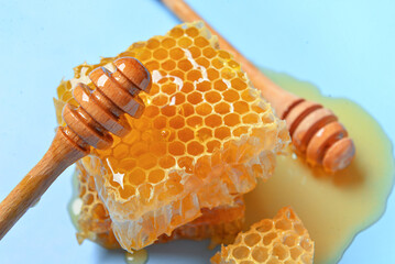 Sweet honeycombs and dippers on blue background