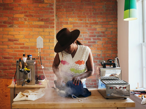 African American Woman Artisan Making A Hat In Workshop