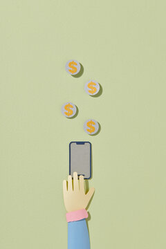 hand with phone and coins falling
