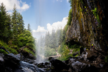 Une cascade en montagne vue de derrière la chute d'eau
