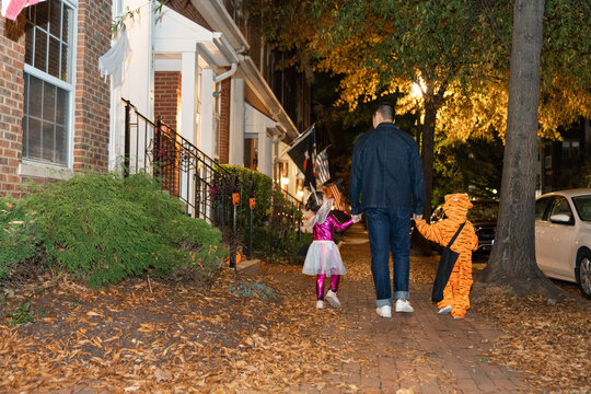 father walking on halloween with daughters