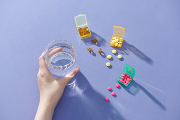 Top view medical tablets, capsules, nutrition supplements and glass