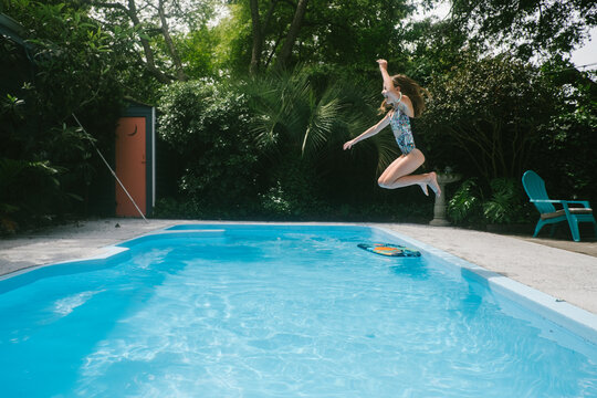Girl jumps into backyard pool
