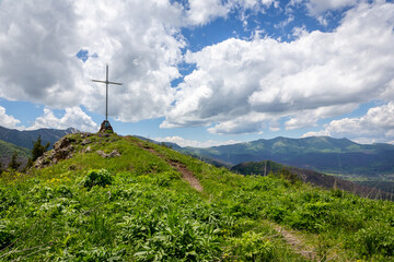 Roadside religious cross with orthodox Saint icon on a hill on M-20 road to Tskhratskaro Pass with...