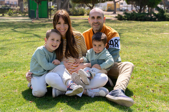 Happy family sitting on grass
