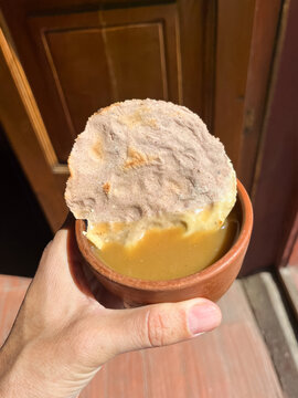 Point of view of a person holding a clay cup with a tostada