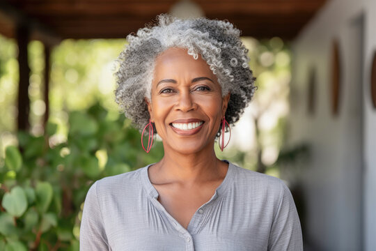 Beautiful senior African-American or black woman in her sixties, smiling, radiating warmth and positivity, expressing confidence and joy.