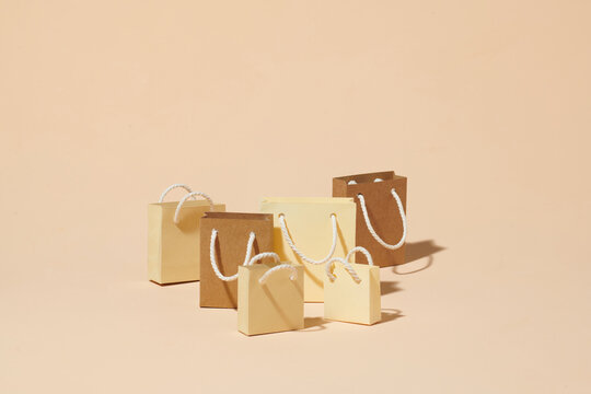 Different paper shopping bags isolated on beige
