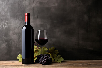 Vintage bottle of red wine with blank matte black label, bunch of grapes on wooden table, concrete wall background. Expensive bottle of cabernet sauvignon concept. Mock up. High quality photo - obrazy, fototapety, plakaty