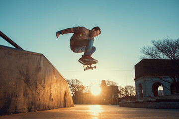 Skateboarder saltando alto en una rampa - obrazy, fototapety, plakaty