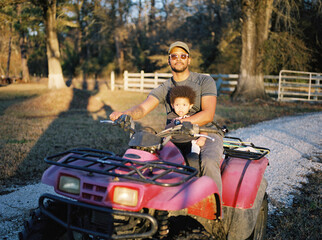A father with his toddler on an ATV