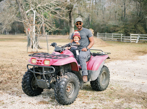 A father with his toddler on an ATV
