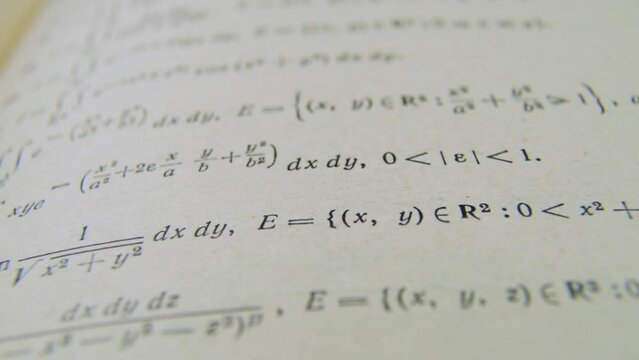 Formulas mathematic formulae equations on paper integral book. Mathematical equations tasks formulas printed on old paper camera slide. Studying.