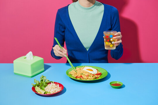 People using chopsticks to eat instant noodles soup with egg served