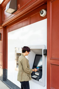 Person With Short Hair Uses Bank ATM