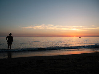 Fototapeta na wymiar Person Boy Girl looking at horizon during sunset in italy at the mittelmeer Sea Enjoy dawn at mare