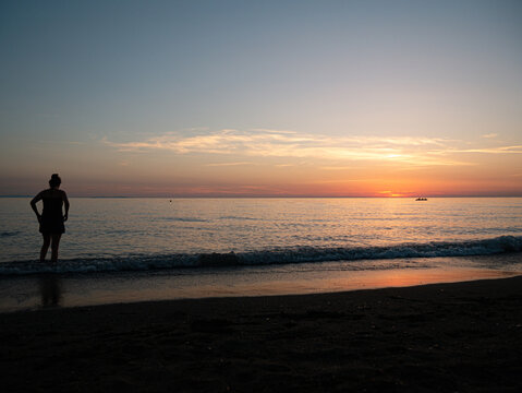Person Boy Girl looking at horizon during sunset in italy at the mittelmeer Sea Enjoy dawn at mare © MrJeans