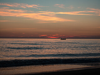 Sunset in Italy Toskana at mittelmeer with fishing boat in the water