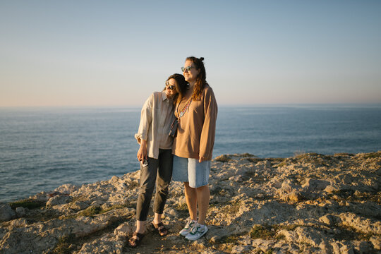 Women enjoying sunset on a cliff