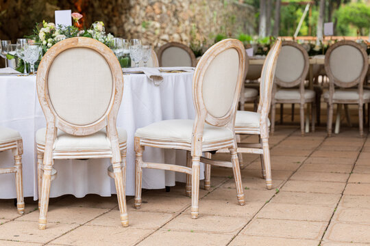 Elegant oval white chairs at a wedding reception