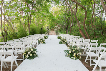 An outdoor wedding surround by big green tres