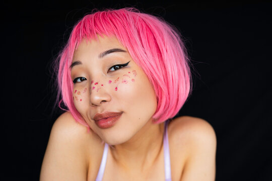Smiling asian woman with pink hair