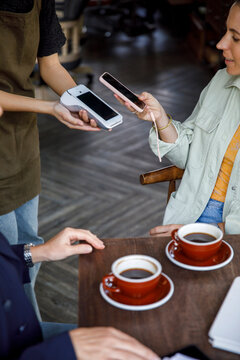 Customer using mobile phone phone for payment at cafe restaurant