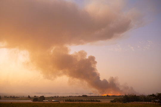 Accidental fire and colourful smoke during the sunset with big cloud