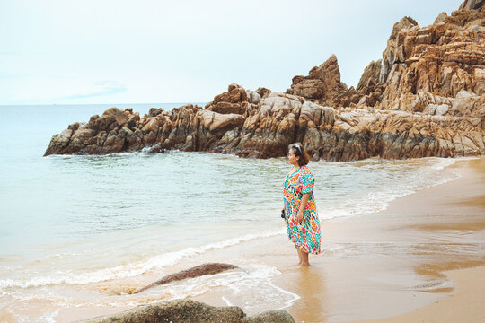 A Curvy Woman Walking Along The Beach.