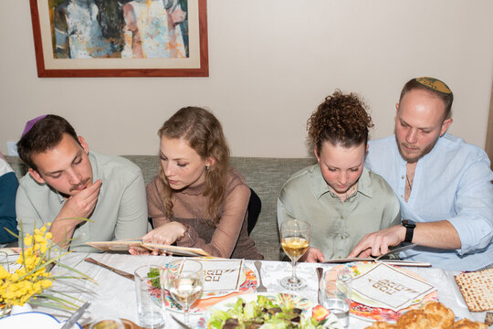 Jewish Family Celebrate Passover Seder Reading the Haggadah.