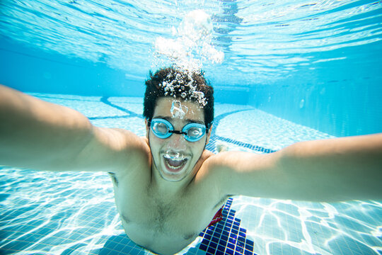 Teenage boy having fun and making selfie underwater