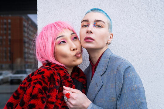 Stylish female LGBT couple with dyed hair in urban city