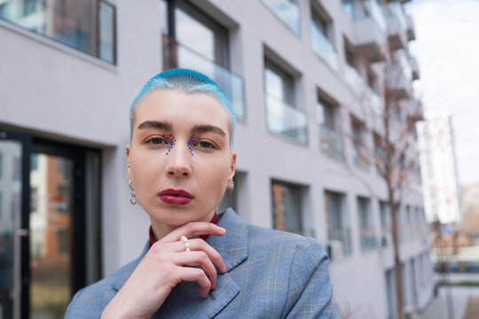 Stylish woman with makeup touching face