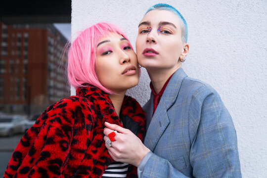Stylish female LGBT couple with dyed hair in urban city