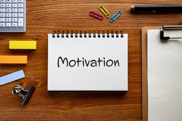 There is notebook with the word Motivation. It is as an eye-catching image.