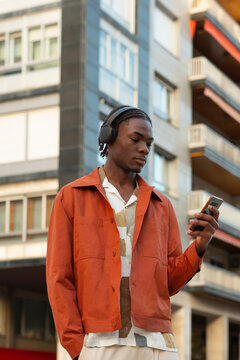 Handsome black man listening to music in the city