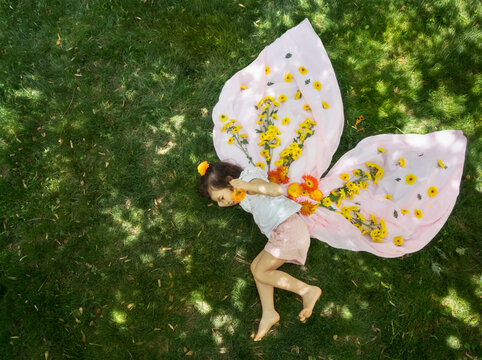 Fairy tale like image of little girl with flower butterfly wings