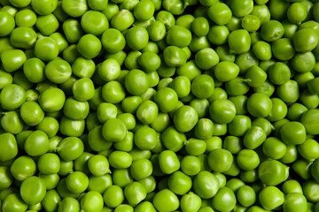 Background of fresh organic sweet green peas, pea grains close-up, top view.