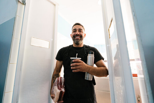Cheerful butcher drinking mate uruguayo